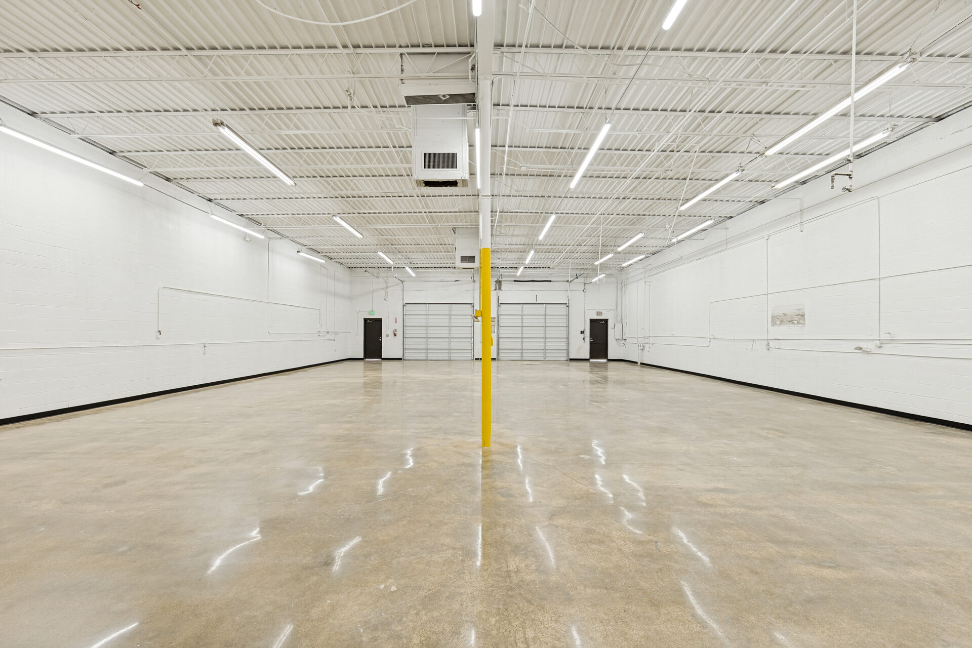 400 Bishop Ave renovation — renovated warehouse bay with polished concrete floors and new overhead doors, Richardson TX
