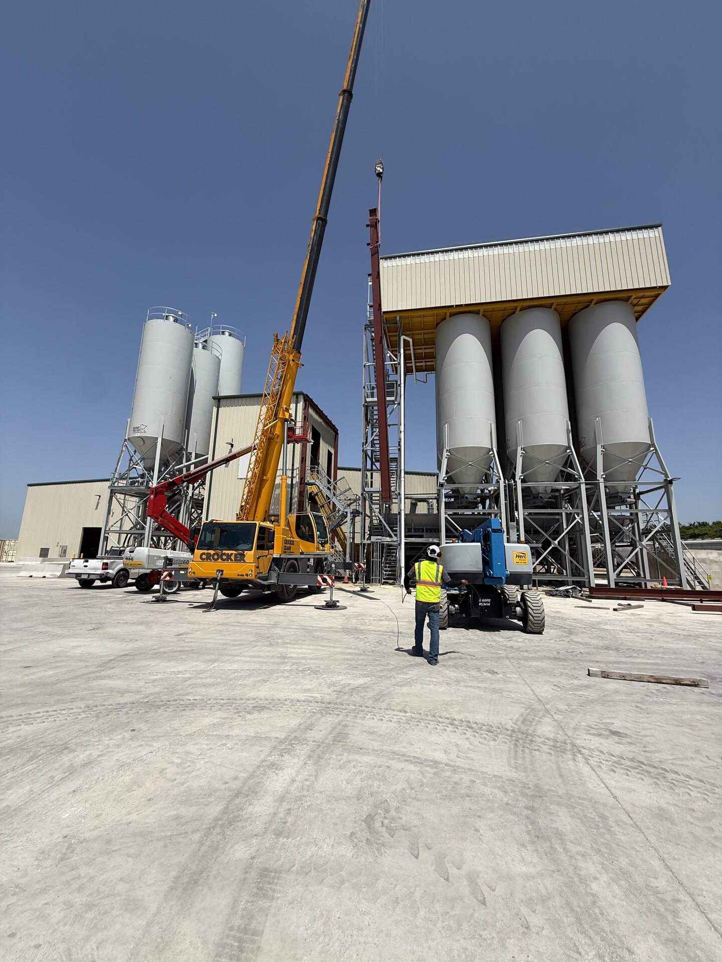 Crane lifting a steel column during erection at the Oldcastle plant in Denton